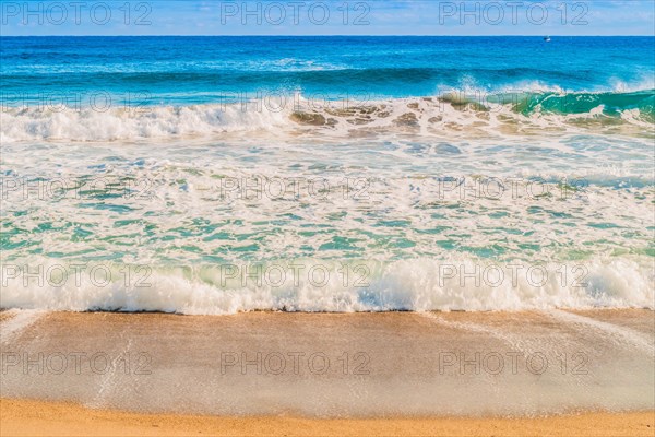 Seascape of whitecaps and waves as tide rolls in to shore on beautiful winter morning under partly cloudy sky, in South Korea