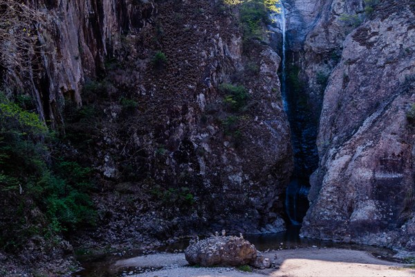 A secluded waterfall tucked away in a shadowy ravine, in South Korea