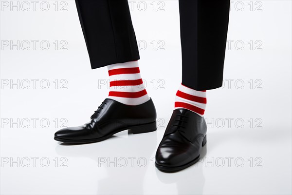 Man's black elegant business shoes with unusual funny red and white striped socks on white background. KI generiert, generiert AI generated