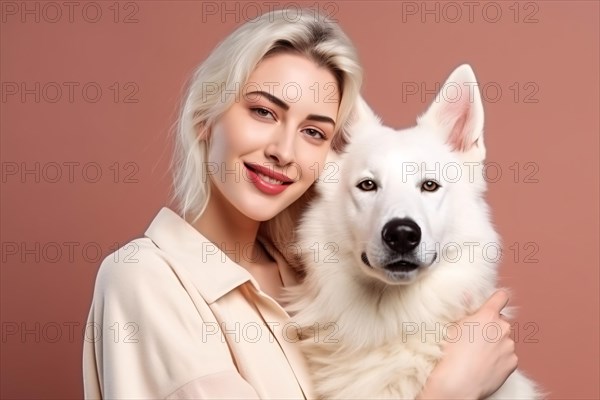 Young woman hugging white Shepherd dog in front of peach colored studio background. KI generiert, generiert AI generated