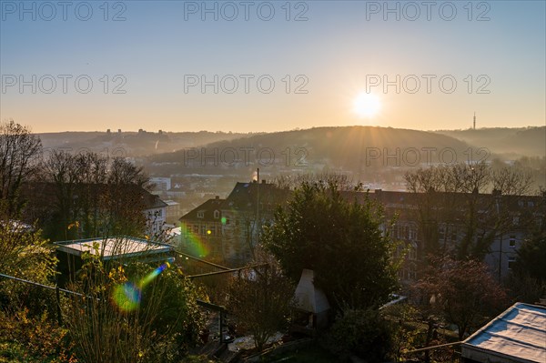 Sunrise over a misty landscape with a view of houses and bare trees in winter, Arrenberg, Elberfeld, Wuppertal, Bergisches Land, North Rhine-Westphalia