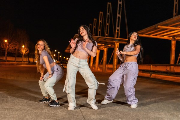 Young dance company performing hip hop dance in the street at night