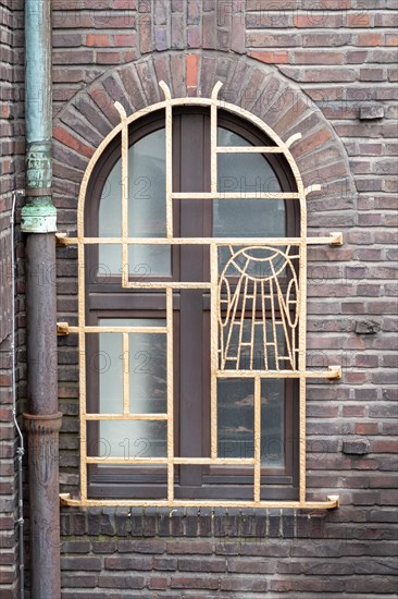 Decorated Art Nouveau window in a red brick wall