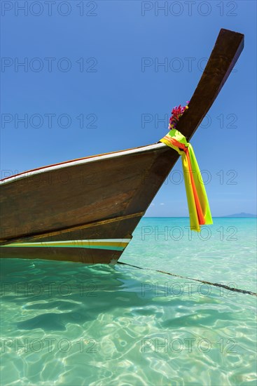 Longtail boat, fishing boat, wooden boat, boat, decorated, tradition, traditional, faith, cloth, colourful, bay, sea, ocean, Andaman Sea, tropics, tropical, island, water, beach, beach holiday, Caribbean, environment, clear, clean, peaceful, picturesque, sea level, climate, travel, tourism, paradisiacal, beach holiday, sun, sunny, holiday, dream trip, holiday paradise, paradise, coastal landscape, nature, idyllic, turquoise, Siam, exotic, travel photo, sandy beach, seascape, Phi Phi Island, Thailand, Asia