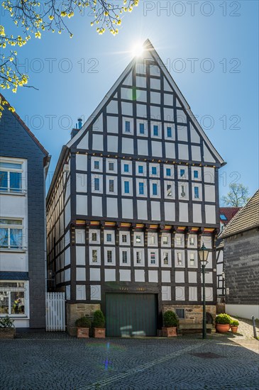 Large, impressive half-timbered house under a bright blue sky with rays of sunshine, Old Town, Hattingen, Ennepe-Ruhr district, Ruhr area, North Rhine-Westphalia