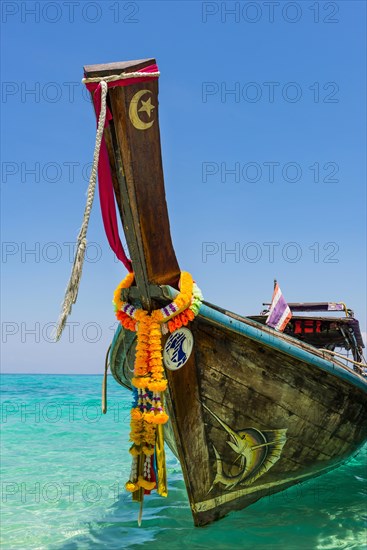 Longtail boat, fishing boat, wooden boat, decorated, tradition, traditional, faith, cloth, colourful, bay, sea, ocean, Andaman Sea, tropical, tropical, island, water, beach, beach holiday, Caribbean, environment, clear, clear, clean, peaceful, picturesque, sea level, climate, travel, tourism, paradisiacal, beach holiday, sun, sunny, holiday, dream trip, holiday paradise, paradise, coastal landscape, nature, idyllic, turquoise, Siam, exotic, travel photo, sandy beach, Phi Phi Island, Thailand, Asia