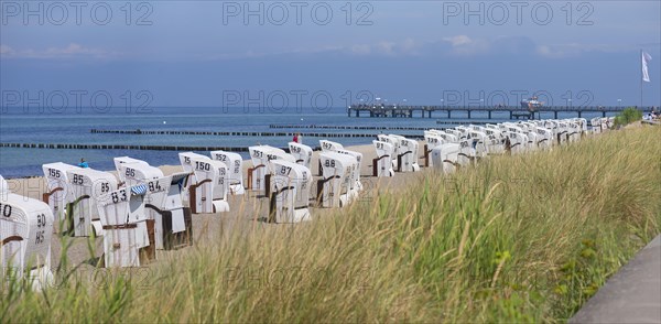 White beach chairs on the beach, behind the pier in Kuehlungsborn, Mecklenburg-Vorpommern, Germany, Europe