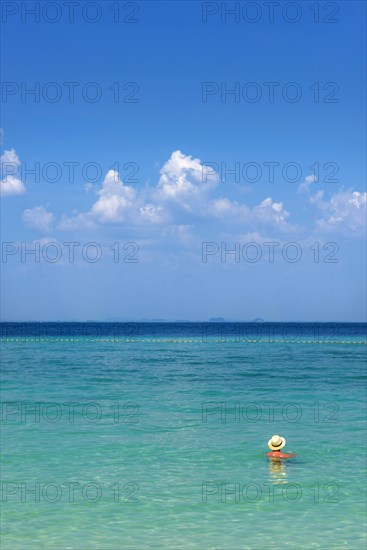 Man with hat bathing in the sun in the sea, ocean, Andaman Sea, ozone, heat, sunstroke, sunscreen, skin cancer, protection, protect, caution, tropics, tropical, summer holiday, summer, water, beach, bathing, swimming, beach holiday, Caribbean, environment, clear, clean, peaceful, climate, travel, tourism, paradisiacal, beach holiday, sun, sunny, holiday, paradise, nature, idyllic, turquoise, exotic, travel photo, sandy beach, seascape, Phi Phi Island, Thailand, Asia
