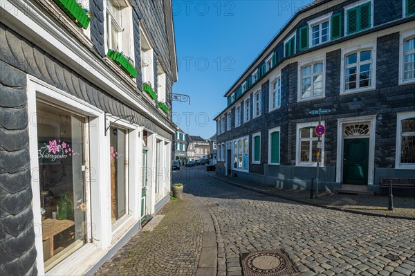 A clearly cobbled street with old half-timbered houses and a blue sky above, Graefrath, Solingen, Bergisches Land, North Rhine-Westphalia