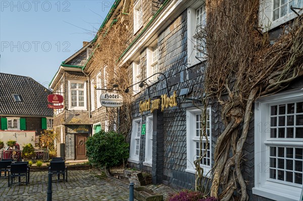 Old half-timbered house with the sign of 'Hotel Wirtshaus zum Scharfenstein' next to a street lamp, Graefrath, Solingen, Bergisches Land, North Rhine-Westphalia