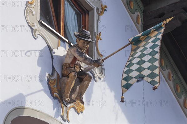 Wooden figure of a boy in lederhosen with Bavarian diamond flag white-blue at the Fraundorfer Inn, Ludwigstrasse, Partenkirchen district, Garmisch-Partenkirchen, Werdenfelser Land, Upper Bavaria, Bavaria, Germany, Europe