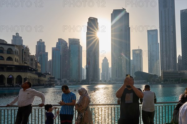 Tourists in front of the skyscraper backdrop at Lake Burj Khalifa. Dubai, United Arab Emirates, Asia