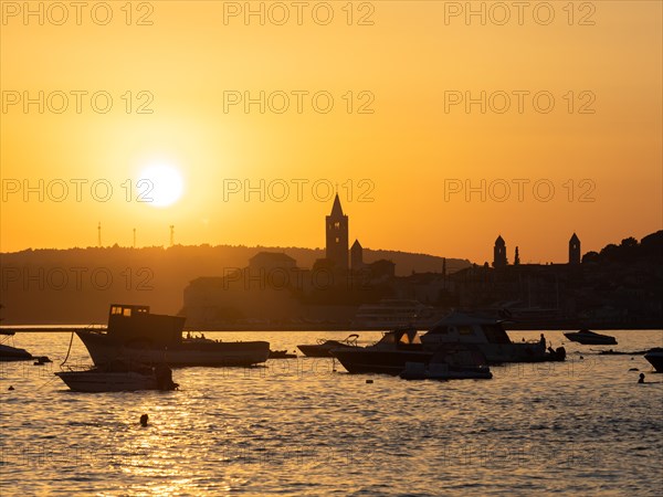 Boats anchoring in a bay, silhouette of a church tower, sunset over Rab, town of Rab, island of Rab, Kvarner Gulf Bay, Croatia, Europe