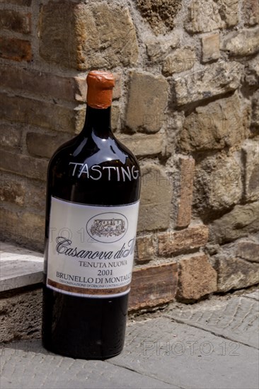 Giant wine bottle as an advertisement and invitation to a wine tasting in front of a wine shop, Montalcino, Province of Siena, Tuscany, Italy, Europe