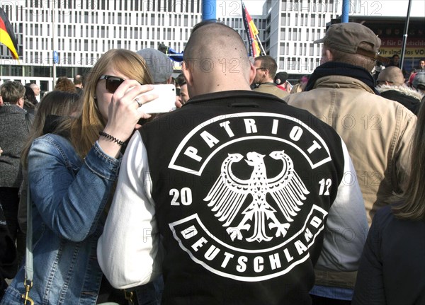 A participant in the Merkel muss weg demonstration wears a jacket labelled Patriot . Demonstration by right-wing populist and right-wing extremist participants, including supporters of the NPD, Pegida, Reichsbuerger, hooligans, Landsmannschaften and Identitarians, Berlin, 4 March 2017