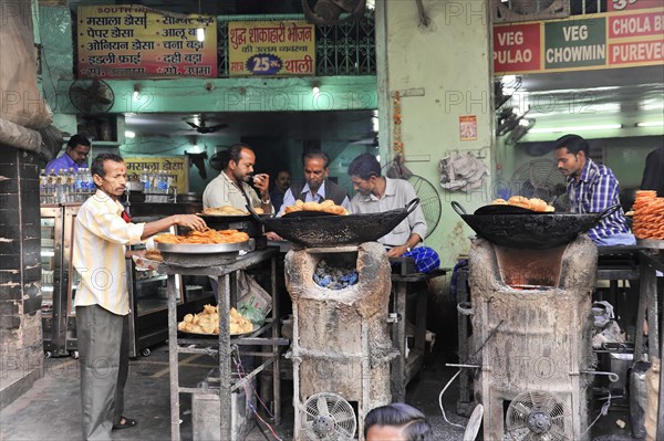 People buying food at a street stall selling freshly prepared food, Varanasi, Uttar Pradesh, India, Asia