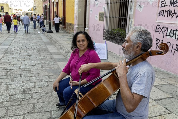 Oaxaca, Mexico, A man and a woman play classical music on the bass and flute. They are playing for tips on the Alcala, a pedestrian-only street, Central America