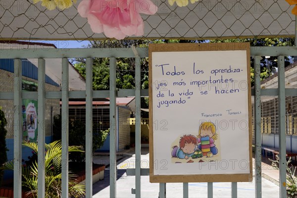 Oaxaca, Mexico, A sign on a schoolyard playground reads: All the most important learning in life is done by playing, Central America