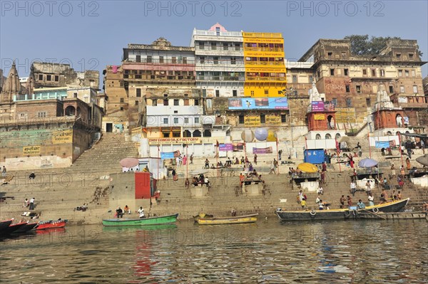 Human life and colourful architecture at the ghats on a busy river, Varanasi, Uttar Pradesh, India, Asia