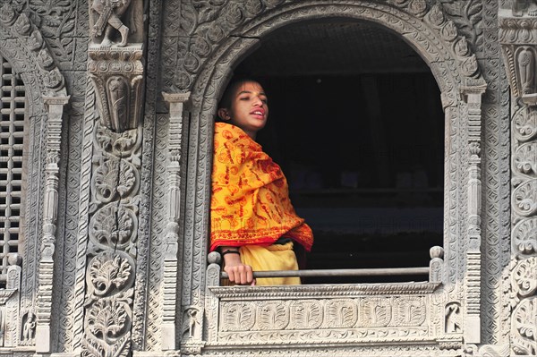 Man in traditional outfit leaning against a richly decorated window, Varanasi, Uttar Pradesh, India, Asia