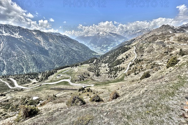 Photo with reduced dynamic saturation HDR of mountain pass alpine pass alpine mountain road alpine road pass road pass in Italian Alps view from pass summit of mountain pass Jaufenpass on southern ramp with southern ascent, Alps, Passo di Monte Giovo, Alto Adige, South Tyrol, Italy, Europe