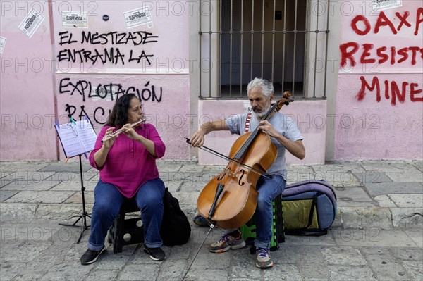 Oaxaca, Mexico, A man and a woman play classical music on the bass and flute. They are playing for tips on the Alcala, a pedestrian-only street, Central America