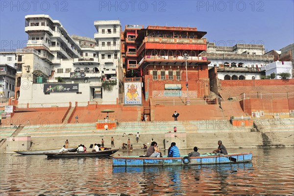 People on boats at ghats in front of traditional buildings in a cityscape, Varanasi, Uttar Pradesh, India, Asia