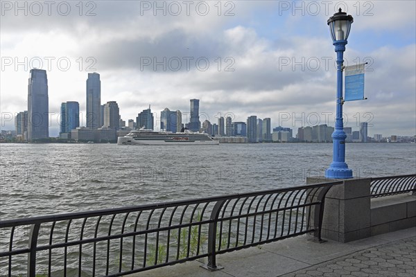 Street lamp marking the potential future flood level caused by global warming, in the background skyline of Jersey City, Hudson River, Lower Manhattan, New York City, New York, USA, North America