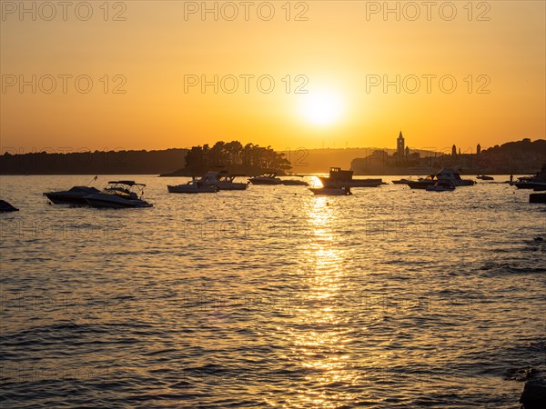 Boats anchoring in a bay, silhouette of a church tower, sunset over Rab, town of Rab, island of Rab, Kvarner Gulf Bay, Croatia, Europe