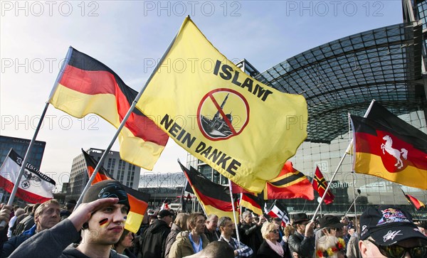 A participant in the Merkel muss weg demonstration holds a flag with the inscription Islam nein Danke . Demonstration by right-wing populist and right-wing extremist participants, including supporters of the NPD, Pegida, Reichsbuerger, hooligans, Landsmannschaften and Identitarians, Berlin, 4 March 2017