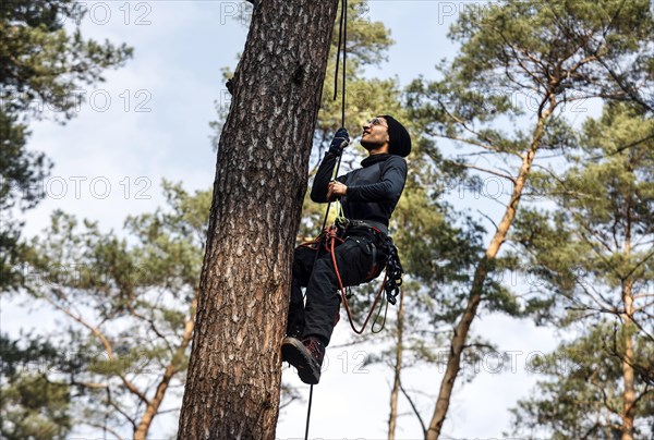 An activist pulls himself up a rope to one of the tree houses in the Gruenheide forest. The activist group Stop Tesla has built tree houses in the forest to protest against the planned expansion of the Tesla plant, 04/03/2024