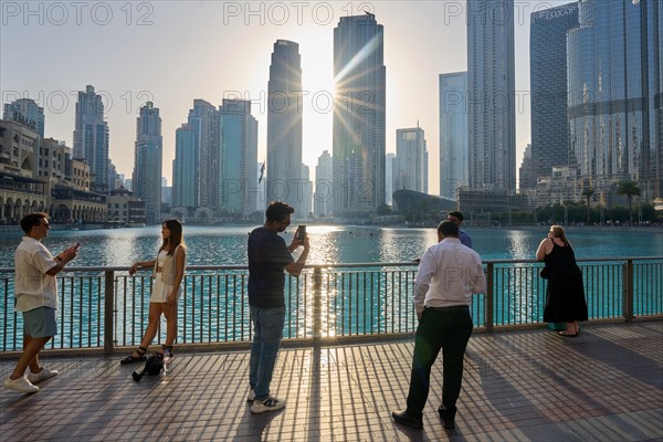 Tourists in front of the skyscraper backdrop at Lake Burj Khalifa. Dubai, United Arab Emirates, Asia
