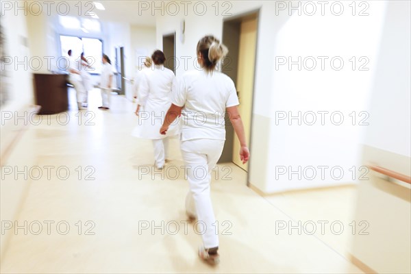 Nurses and care staff walk across a corridor in a clinic in Berlin, 25/01/2019