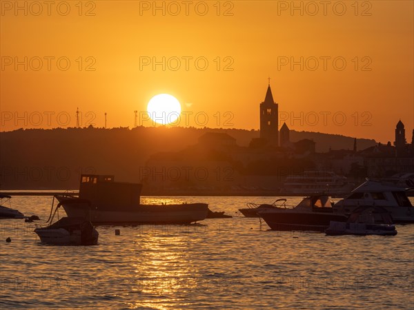 Boats anchoring in a bay, silhouette of a church tower, sunset over Rab, town of Rab, island of Rab, Kvarner Gulf Bay, Croatia, Europe