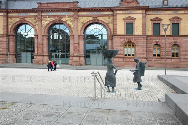 Sculpture Shoe carrier and monument to former shoe industry in front of the Old Post Office built in 1893, people, neo-renaissance, entrance with glass window and decorations, shoe production, shoe carrier, carrier, shoes, shoe, head, carry, back, rucksack, historical, Pirmasens, Palatinate Forest, Rhineland-Palatinate, Germany, Europe