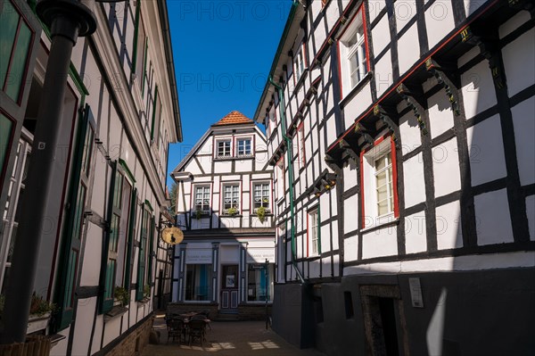 View of a quiet cafe between half-timbered houses on a sunny day, Old Town, Hattingen, Ennepe-Ruhr district, Ruhr area, North Rhine-Westphalia
