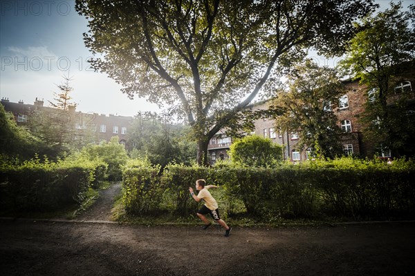 Nikiszowiec, Poland, 14 April 2020: A boy running through green courtyard in the mining district of Katowice, Silesia, Europe