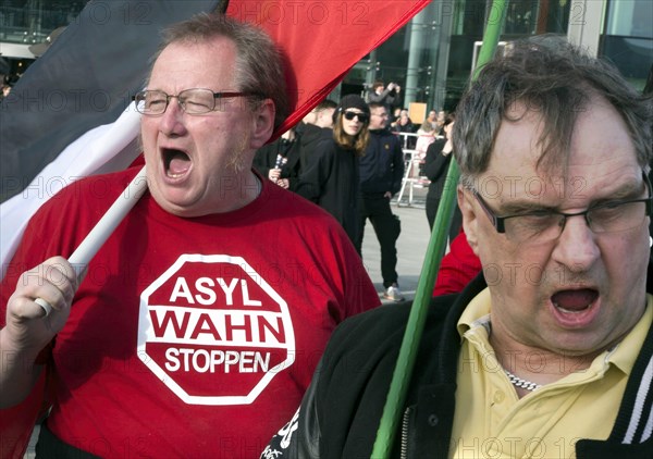 A participant in the Merkel muss weg demonstration wears a shirt with the inscription Asylwahn stoppen . Demonstration by right-wing populist and right-wing extremist participants, including supporters of the NPD, Pegida, Reichsbuerger, hooligans, Landsmannschaften and Identitarians, Berlin, 04 March 2017