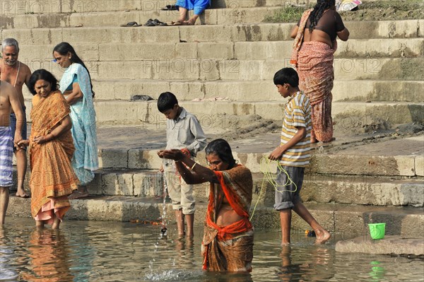 People performing ritual acts in water near river steps, Varanasi, Uttar Pradesh, India, Asia