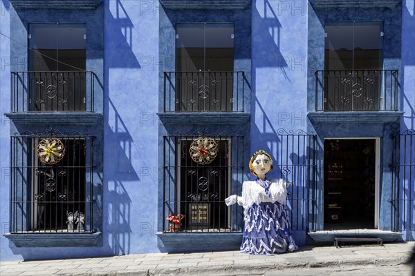 Oaxaca, Mexico, A giant papier mache puppet (mono de calenda) in front of a store on Calle Macedonio Alcala, a busy street open only to foot traffric, Central America