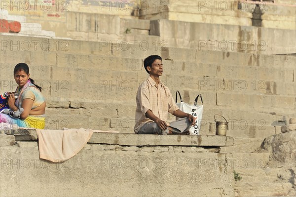 Single person praying on the steps of the ghats in the morning light, Varanasi, Uttar Pradesh, India, Asia