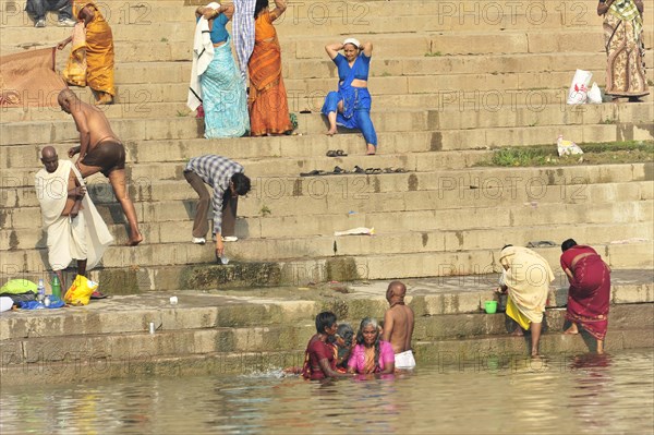 People bathing and washing on the river bank, immersed in the cultural routine, Varanasi, Uttar Pradesh, India, Asia