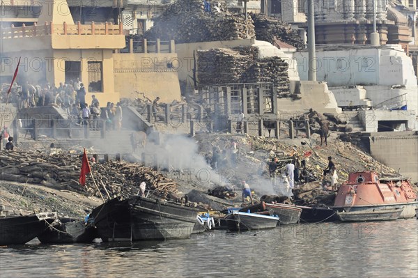 Dense smoke over a riverbank where people participate in religious practices, Varanasi, Uttar Pradesh, India, Asia