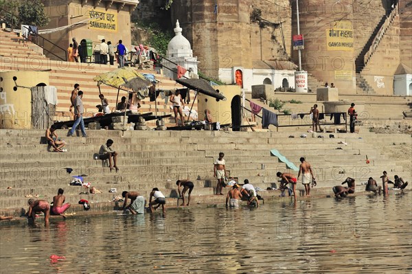 People bathing and socialising at the busy ghats of an Indian river, Varanasi, Uttar Pradesh, India, Asia