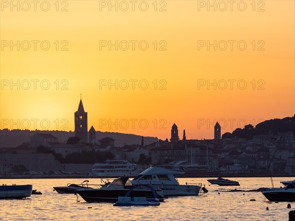 Boats anchoring in a bay, silhouette of church towers, evening mood after sunset over Rab, town of Rab, island of Rab, Kvarner Gulf Bay, Croatia, Europe