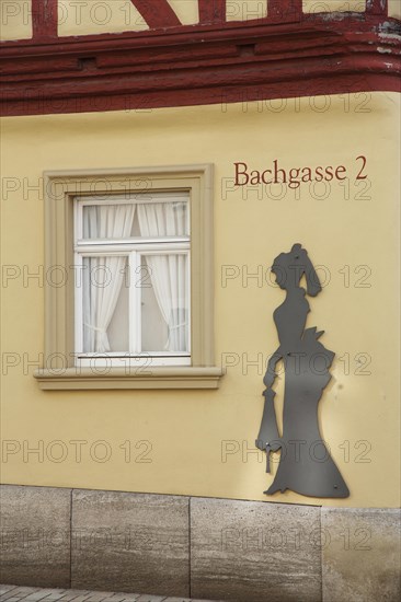 House wall with figure at the historic Malerwinkelhaus built in 1774 and museum, female figure, lady, silhouette, alleyway name, house number, 2, yellow half-timbered house, yellow, Bachgasse, Marktbreit, Lower Franconia, Franconia, Bavaria, Germany, Europe