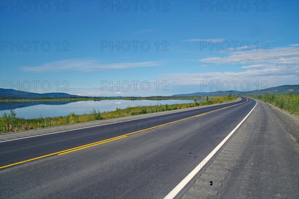 Endless straight road along a lake, late summer, Alaska Highway, Alaska, USA, North America