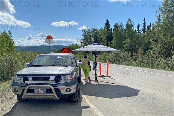 Construction worker directing traffic at the beginning of a construction site, Alaska Highway, Tok, Alaska, USA, North America