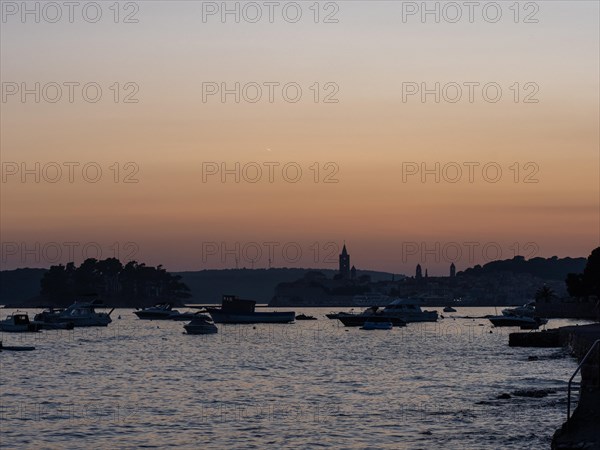 Boats anchoring in a bay, church towers, evening mood after sunset over Rab, town of Rab, island of Rab, Kvarner Gulf Bay, Croatia, Europe