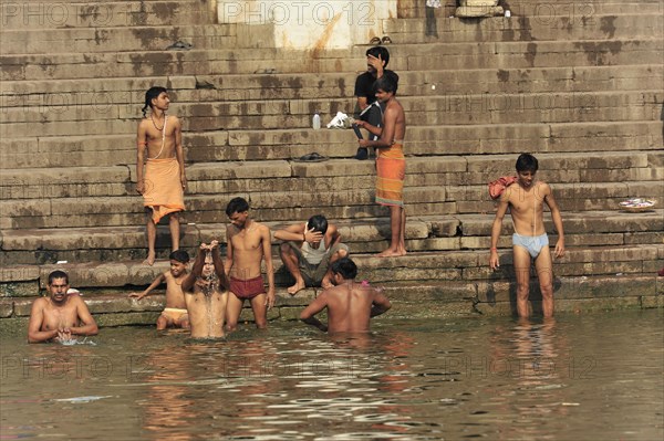 People performing ritual bathing and social interactions at the ghats of a river, Varanasi, Uttar Pradesh, India, Asia